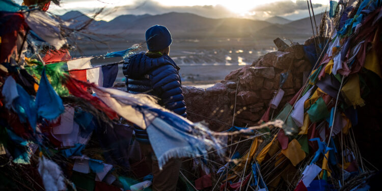 Thom Pollard in Tingri, catching a first glimpse of Mt. Everest at sunset. (National Geographic/Renan Ozturk)